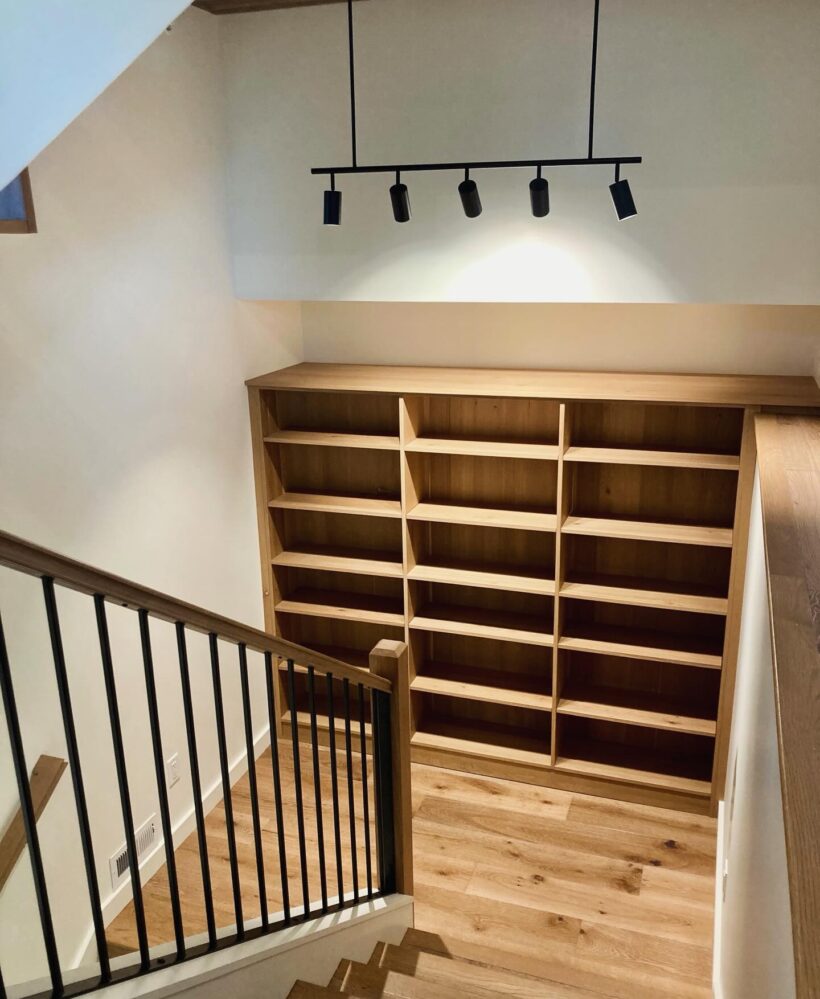 view looking down stairs with a custom bookcase and lighting